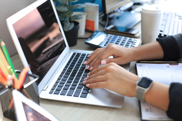 Close up of female hands busy typing on laptop in modern office.