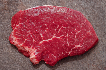 raw steak, a slice of marbled beef on the kitchen countertop