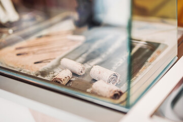 Stir-fried ice cream rolls at freeze pan. Handmade rolled ice cream dessert on cold plate. Fried ice cream machine with steel chilled pan.