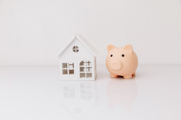 Piggy bank and house model. Savings concept