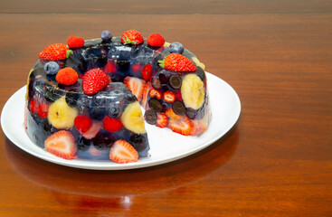 Sliced red fruit jelly in closeup on the wooden table