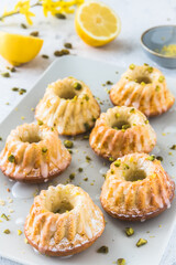 Homemade delicious mini lemon bundt cakes (muffins) on white background, vertical