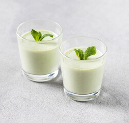 Vegan dessert creamy pudding green mint in a glass on a light gray background