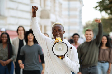 Emotional black guy activist with megaphone on the street