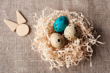 Obraz premium easter eggs in the nest wooden hare icon on a crafting background