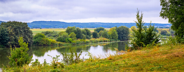 Autumn landscape with trees by the river. Panorama
