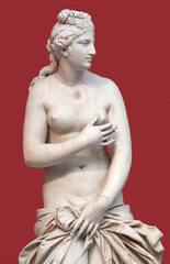 Fototapeta na wymiar Marble ancient Greek statue of the Goddess Aphrodite (Venus) on a red background. Goddess of love, beauty and sexuality. Roman copy of 2nd century A.D.