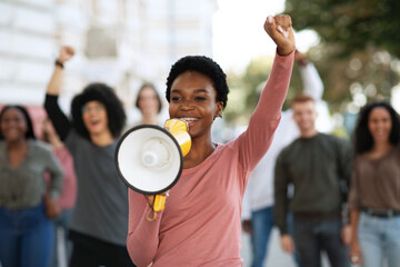 Female leader of strikers with loudspeaker yelling demands to government