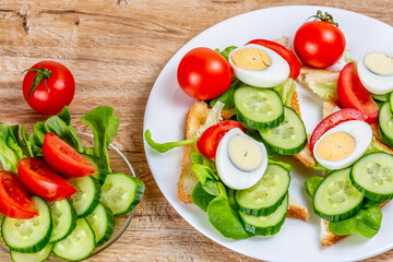 Fried bread toasts with vegetable and egg slices and salad