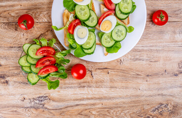 Fried bread toasts with vegetable and egg slices and salad