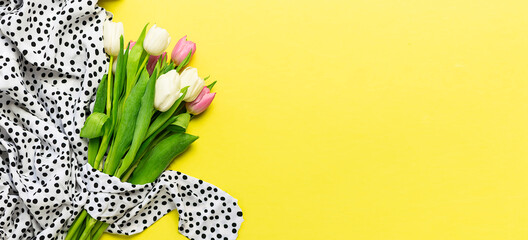 Long wide banner with polka dot silk dress and bouquet of beautiful tulip flowers on bright yellow background. Spring sale banner concept. Fashion blog spring banner.