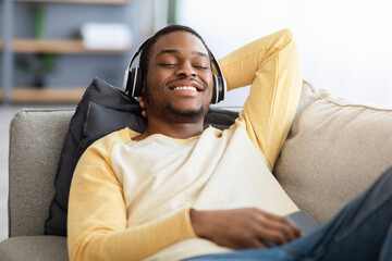 Obraz premium Closeup portrait of happy black guy in wireless headset