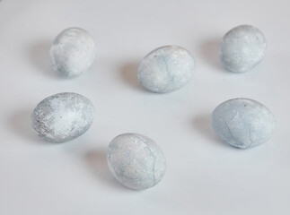 Painted eggs in blue and white lie on a white background.