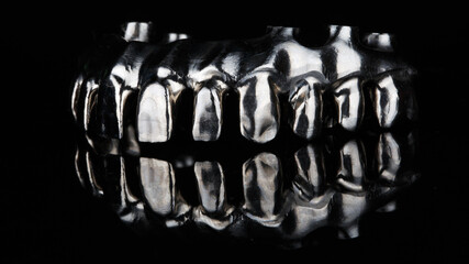 stylish macro photo of a titanium dental bar before creating a prosthesis of the upper jaw on black glass with reflection © Dental Pro Content