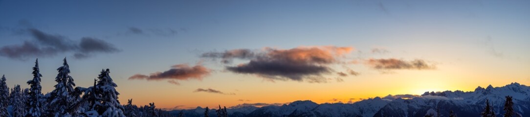 Panoramic View of Canadian Nature Landscape on top of snow covered mountain and trees during colorful spring sunset. Taken on a hike up Elfin Lake in Squamish, North of Vancouver, BC, Canada.