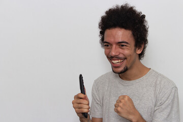 Man on white background with celebrating with remote control in hands