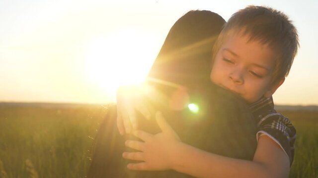 son hugs mom. concept happy family teamwork. boy kid hugs beloved mother sunlight at lifestyle sunset. Womens day concept. parent girl have a tender relationship are in love
