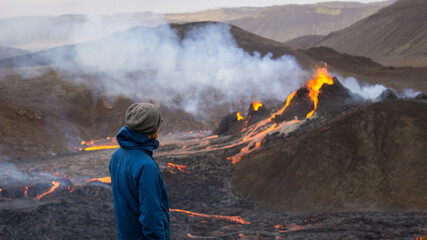 A hiker watches a small volcanic eruption in Mt Fagradalsfjall, Southwest Iceland. A small eruption...