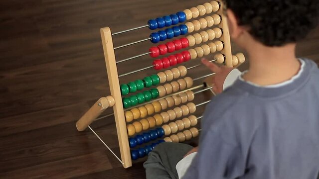 little boy playing with abacus toy at school stock footage