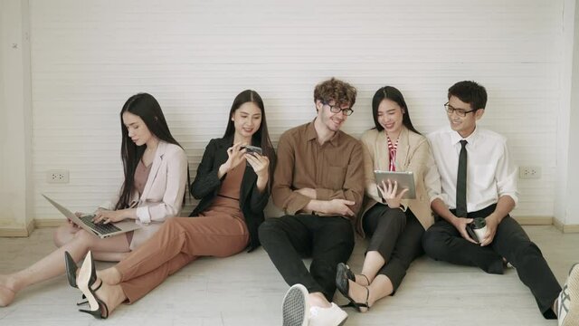 Company employees, business teams or freelancers are sitting on the floor to discuss each other
