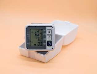 electronic tonometer on the wrist on a beige background