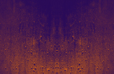 Orange and violet surface of window with rain drops. Moody  night background.