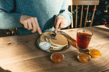 The girl cuts delicious pancakes
