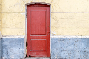 The red wooden door without a lock consists of two sections