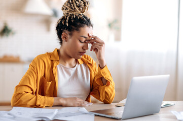 Overworked frustrated young african american student girl or freelancer, in casual clothes,...