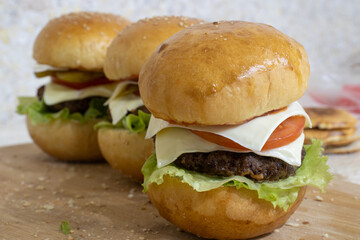 Homemade grilled hamburger on plate with white background. Homemade Beef Burger. Homemade Beef Burgers. Homemade beef burgers with cheese
