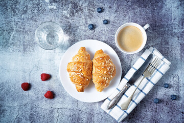 Fresh croissants with berries and cup of coffee