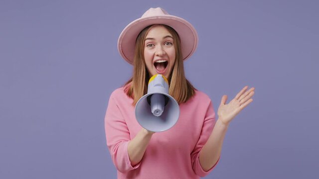 Surprised cheerful blonde young woman 20s years old in casual pink t-shirt hat isolated on violet purple color background in studio. People lifestyle concept. Screaming in megaphone spreading hands