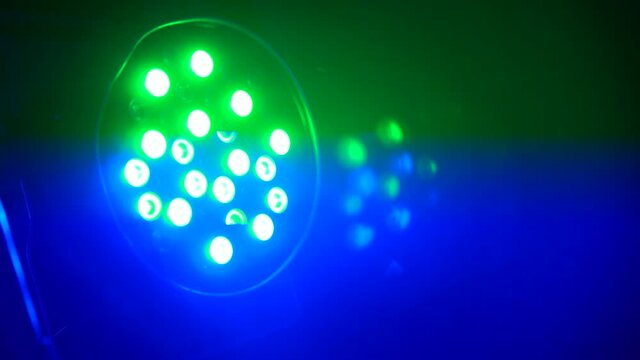 Closeup shot of multicolor projector spot lights on stage. Footage. Shot of searchlight shim with different colors. Party or disco equipment. Entertainment industry concept.