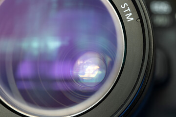 Close up lens of camera with open aperture and reflection.