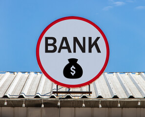 A Circle billboard with sign a Bank and money bag, is installed on a roof. Board with sign of...