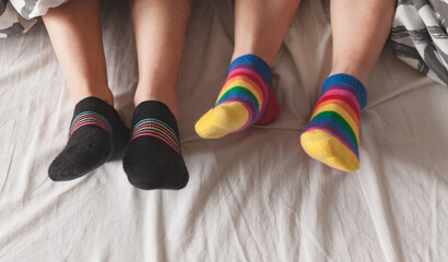 Man with rainbow socks on color background.