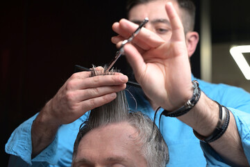 The work of a master with a client's hair in a barbershop, close-up