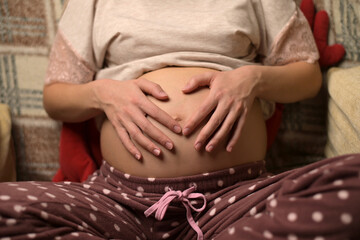 Hands of a pregnant woman on the belly. Woman stroking her belly