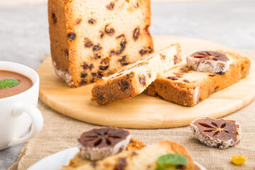Homemade cake with raisins, dried persimmon and a cup of hot chocolate on a gray concrete background. side view, selective focus.