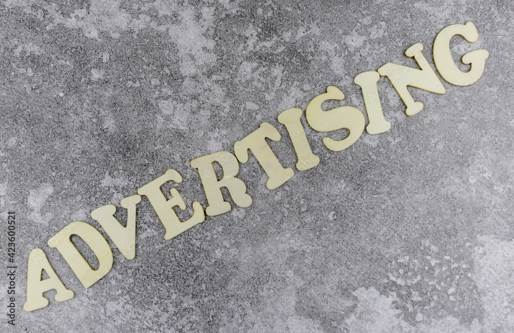 Fototapete advertising concept with diagonal word in alphabet letters on a grey textured background viewed as a