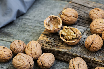 Ripe and raw whole big walnut kernel with shell on rustic backdrop. healthy nut food for brain