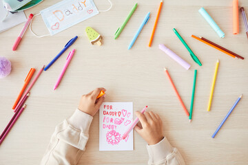 Top view close up of unrecognizable mixed-race child making handmade card as gift for Fathers day, copy space