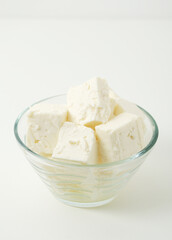 A glass bowl with sheep cheese	