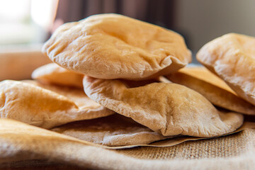 Pile of homemade pita bread. Freshly baked gluten-free pita bread on a rustic cloth, hot from the...