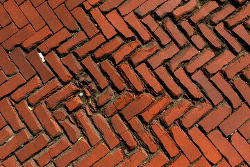 Old weathered and broken chipped brick road from naturally shiny brick pavement, clinker pavement texture