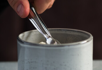 hand pouring milk into glass