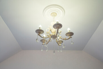 glowing light metal chandelier with crystal in the living room
