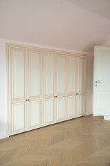 built-in wardrobe in the children's room with parquet and sloping roof