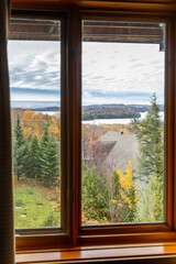 Fototapeta premium vue de la nature avec ciel ennuagé en automne au travers d'une fenêtre