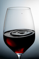 Glass of red wine on a gray background, advertising wine.Vertical photo